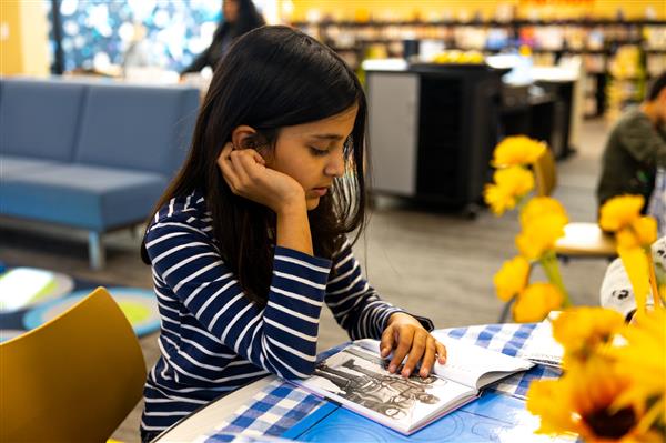 Students browsing new books that have been added to the Scales Library.